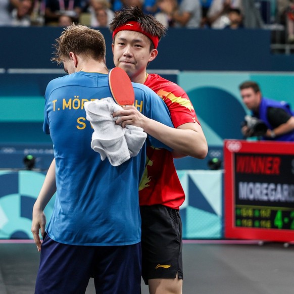 240731 -- PARIS, July 31, 2024 -- Wang Chuqin R of China hugs Truls Moregard of Sweden after the men s singles round of 32 Table tennis, Tischtennis match between Wang Chuqin of China and Truls Morega ...