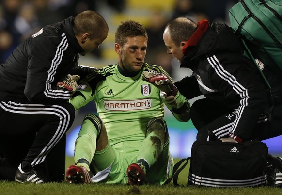 Fulham&#039;s goalkeeper Maarten Stekelenburg&#039;s eye is looked at after a crash with Liverpool&#039;s Luis Suarez during their English Premier League soccer match at Craven Cottage, London, Wednes ...