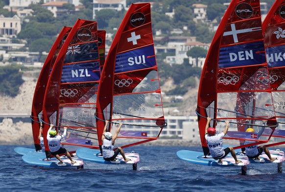 epa11506656 (L-R) Josh Armit of New Zealand, Elia Colombo of Switzerland and Johan Bornemann Soe of Denmark in action during the Men&#039;s Windsurfing opening series race of the Sailing competitions  ...