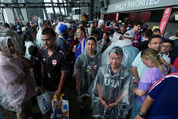 Fans wait in a sheltered area of the stadium as bad weather halts play during the World Cup Group I soccer match between France and Iraq in Philadelphia, Monday, June 22, 2026. (AP Photo/Matt Rourke)
 ...