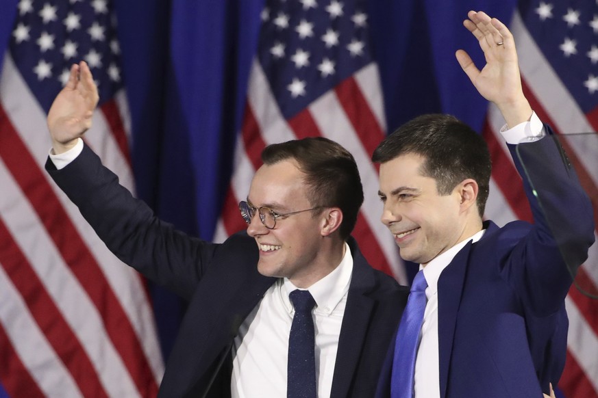 Democratic presidential candidate former South Bend, Ind., Mayor Pete Buttigieg waves with husband Chasten Buttigieg, left, at a primary night election rally in Nashua, N.H., Tuesday, Feb. 11, 2020. ( ...