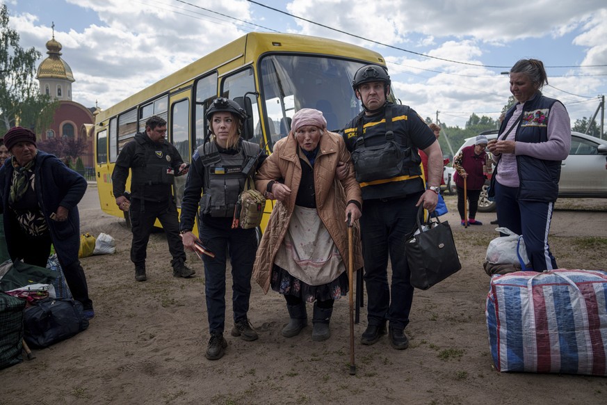 Rescue workers help Liudmila Kalashnik, 88, after evacuation from Vovchansk, Ukraine, Sunday, May 12, 2024. Her husband was killed in their house after a Russian airstrike on the city. (AP Photo/Evgen ...