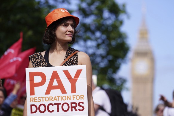 A junior doctor stands on the picket line outside St Thomas&#039; Hospital, London, during their continuing dispute over pay, Thursday June 27, 2024. (Jordan Pettitt/PA via AP)