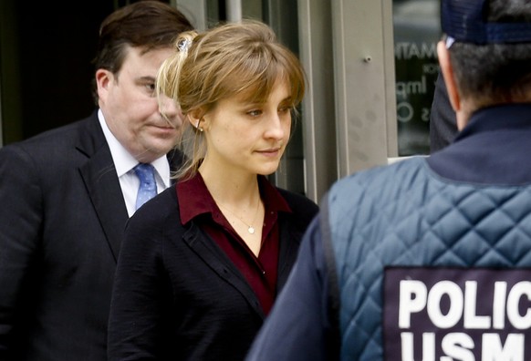 Actress Allison Mack, center, leaves after a hearing in Brooklyn Federal Court, Friday May 4, 2018, in New York. The former &quot;Smallville&quot; actress and Keith Raniere, the leader of the self-hel ...