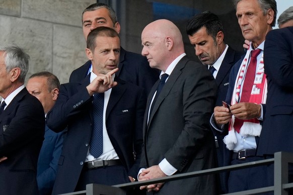 FILE - UEFA President Aleksander Ceferin, left, talks to FIFA President Gianni Infantino before a round of sixteen match between Switzerland and Italy at the Euro 2024 soccer tournament in Berlin, Ger ...