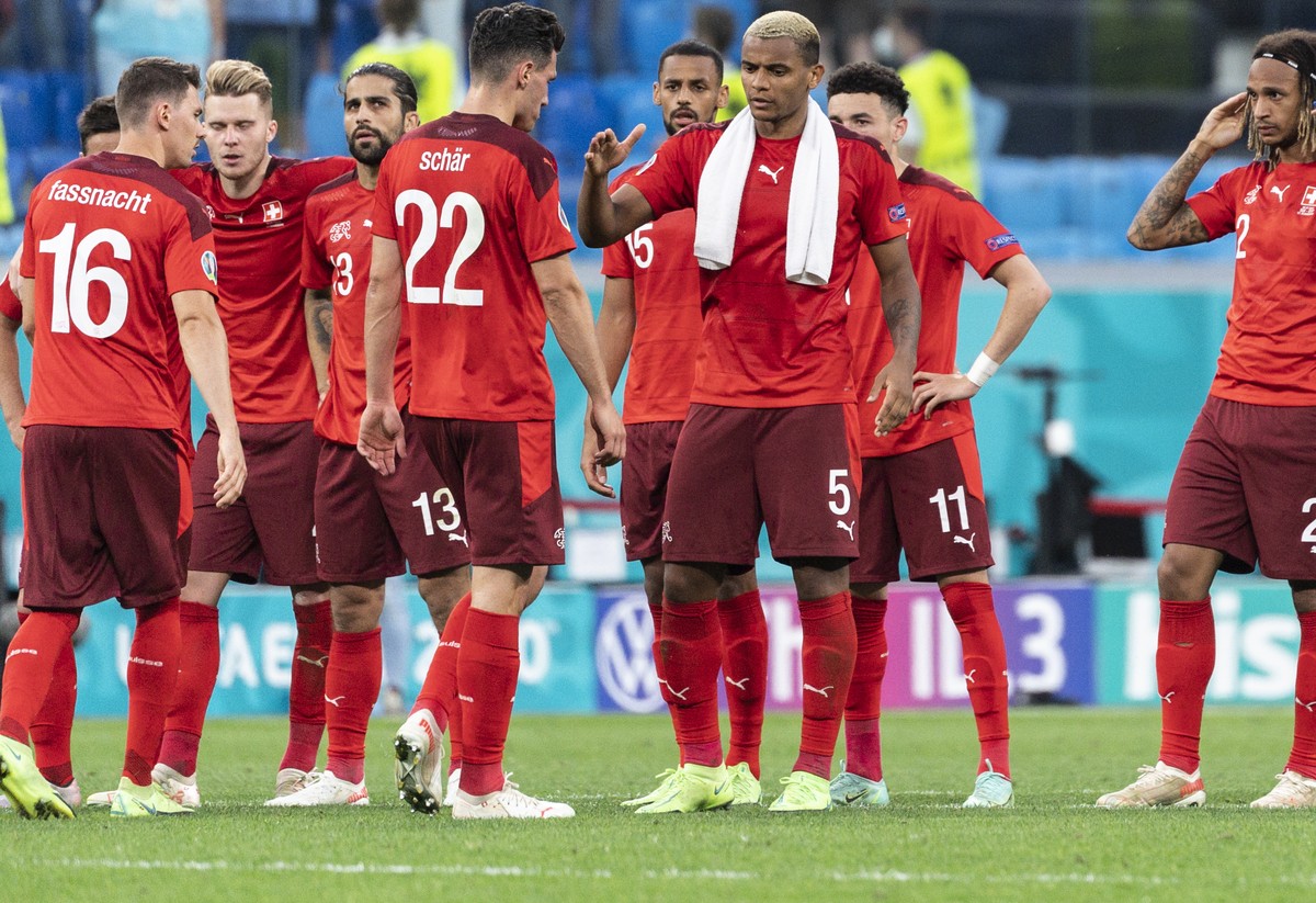 Switzerland's defender Manuel Akanji, nr. 5, comforts defender Fabian Schaer, nr 22, who just missed a penalty, before missing himself, during the UEFA Euro 2020 soccer tournament quarterfinal so ...