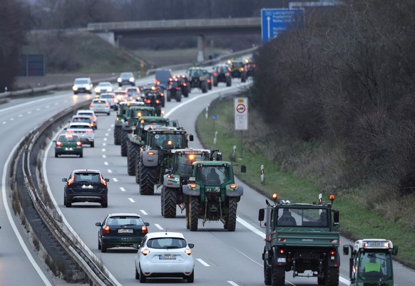 epa11064089 Farmers with their tractors drive on the Highway A65 during a nationwide farmers&#039; strike near Neustadt an der Weinstrasse, Germany, 08 January 2024. Farmers went on strike nationwide  ...