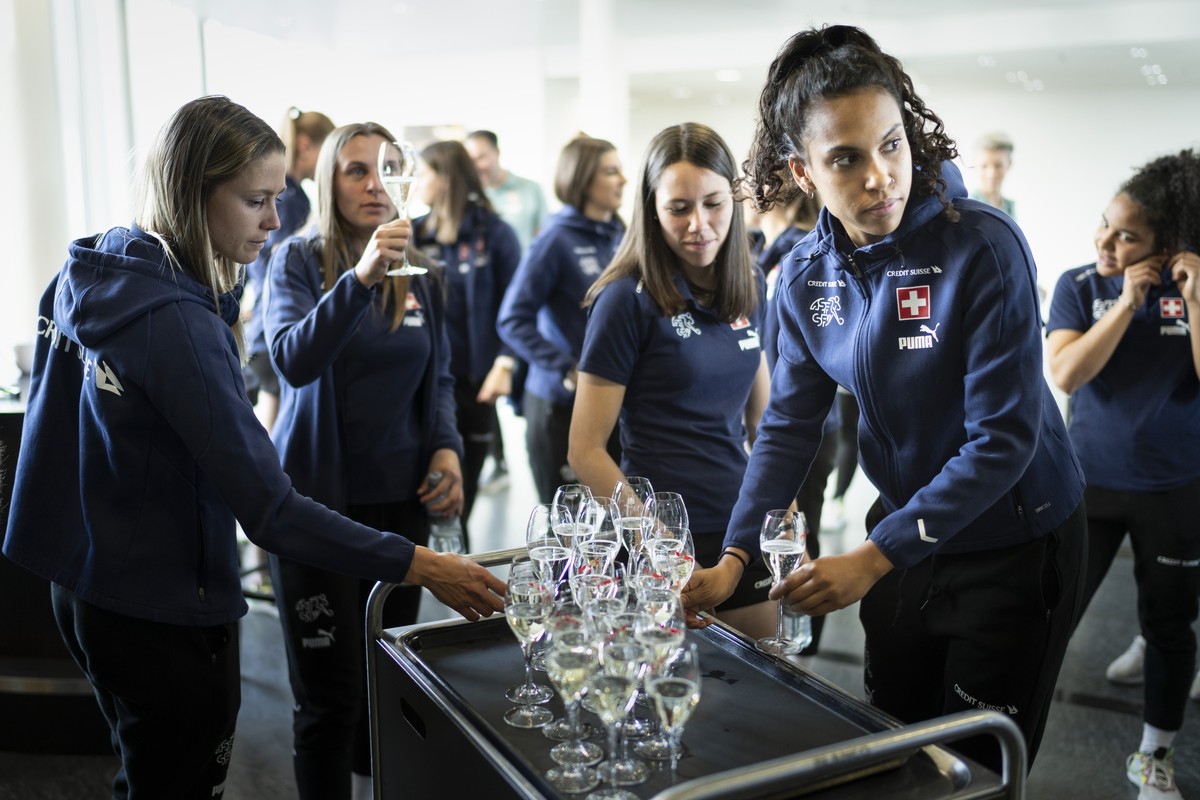 Die Spielerinnen und der Staff der Schweizer Frauen Fussballnationalmannschaft stossen mit Champagner an, um die Entscheidung der uefa zu feiern, die UEFA Woman's EURO 2025 an die Schweiz zu verg ...