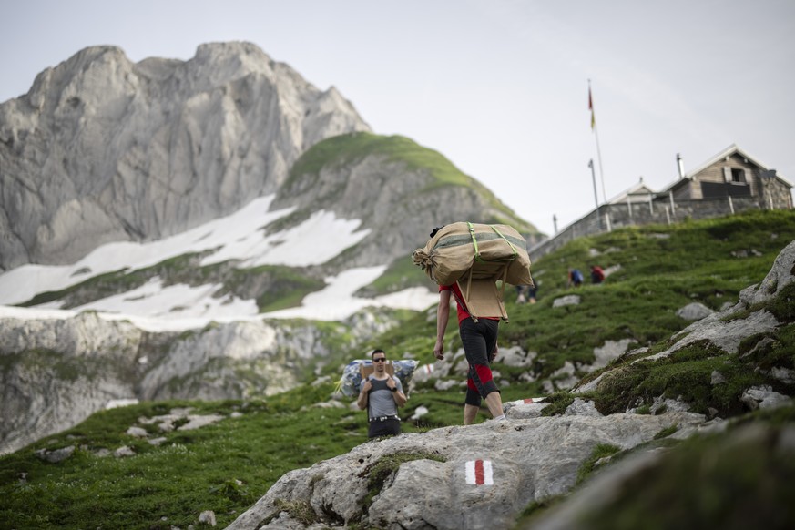 Traeger bei der traditionellen ?Hoettetraegete? (Huettentraegete) zur Zwinglipasshuette SAC auf 1999 Meter ueber Meer, am Samstag, 29. Juni 2024, in Wildhaus. Seit dem Bau der Huette 1971 tragen Freiw ...