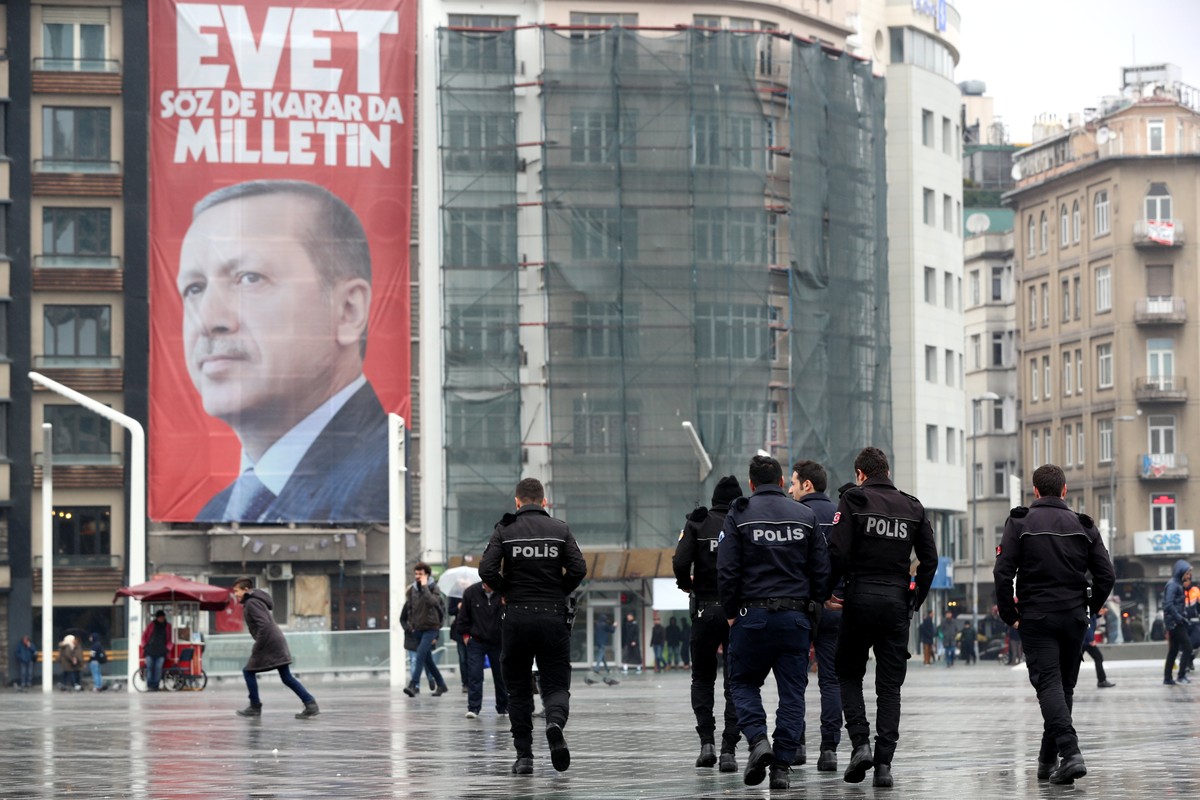 epa05847271 People walk in front of a giant poster of Turkish President Recep Tayyip Erdogan reading 'Vote Yes, only public can speak and make a decision' at Taksim Square in Istanbul, Turke ...