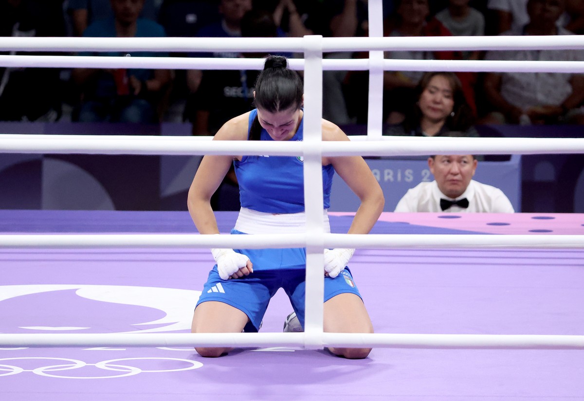 epa11515333 Angela Carini of Italy kneels in the ring as she abandons her bout in the Women 66kg preliminaries round of 16 against Imane Khelif of Algeria of the Boxing competitions in the Paris 2024  ...
