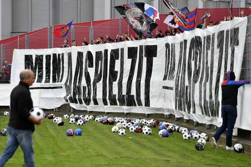 Fans des FC Basel werfen in Winterthur Fussbälle auf das Feld.