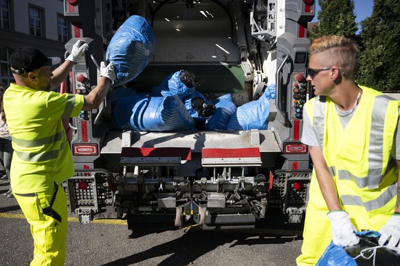 Patrick Schafroth, Belader ERB, links, und Janina Hanni, Fahrerin ERB, werfen die Muellsaecke in den Muellwagen, waehrend einer Medienkonferenz von Stadt Bern zur Containerpflicht und Farbsack-Abfuhr, ...