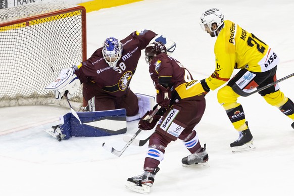 Geneve-Servette&#039;s goaltender Dominic Nyffeler, left, saves a puck past Geneve-Servette&#039;s defender Sami Vatanen, of Finland, center, and Bern&#039;s forward Simon Moser, right, during a Natio ...