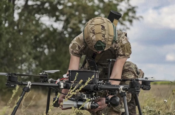 epa11623824 A still image taken from an undated handout video made available by the Russian Defence Ministry Press Service on 24 September 2024 shows a Russian serviceman prepares a hexacopter drone f ...